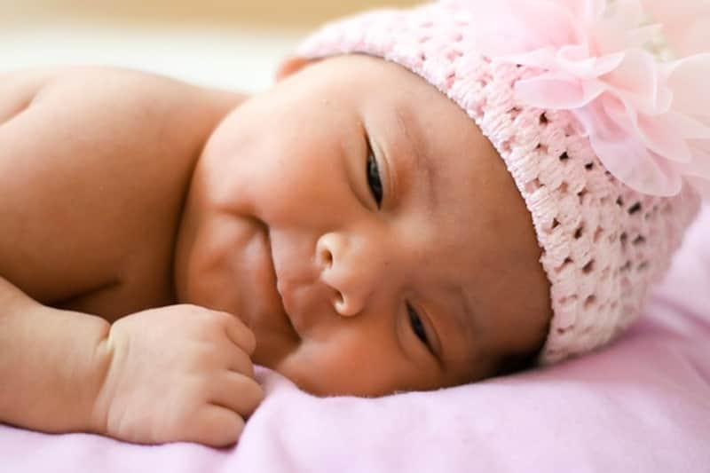 Bébé fille asiatique avec un bonnet rose