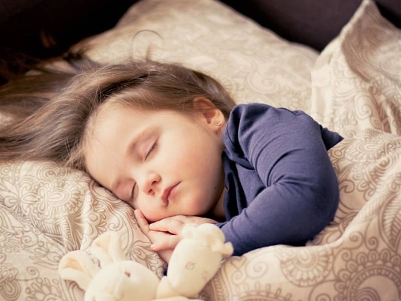 Petite fille qui dort avec sa peluche