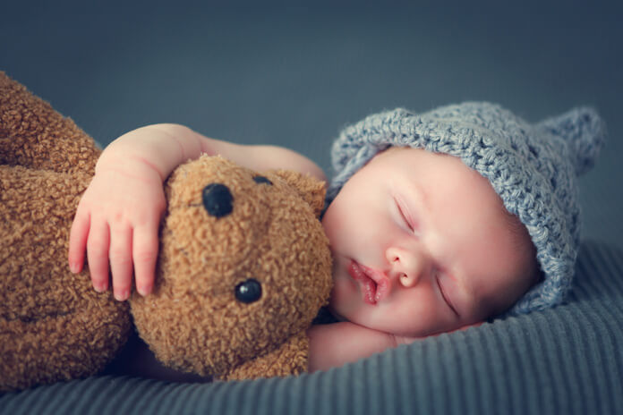Bébé qui dort profondément avec une peluche