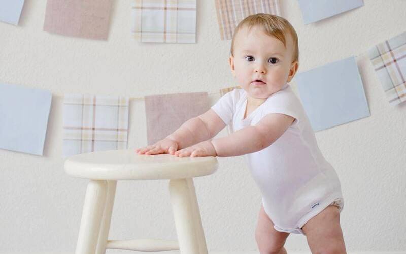 Photo de bébé 9 mois debout en appui