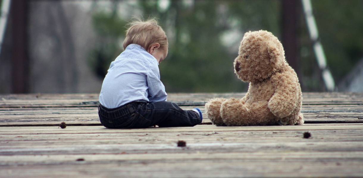 Bébé de 13 mois assis face à son ours en peluche
