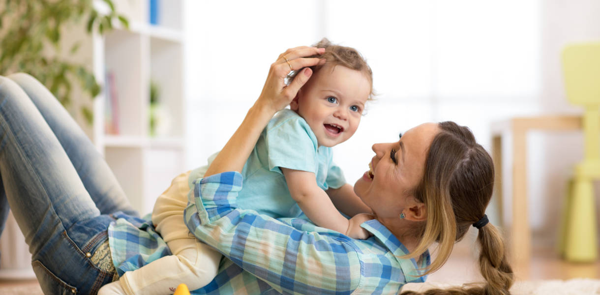 Mère et fils heureux, allongés sur le sol et jouant à l'intérieur