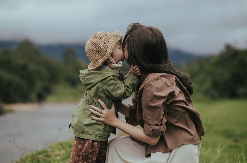 bébé qui fait un bisou à sa maman